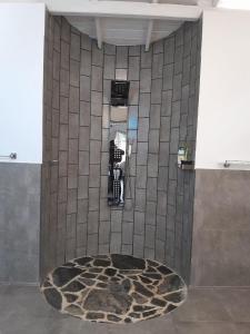 Eine Person steht in einem Badezimmer mit gefliestem Boden. in der Unterkunft villa cinnamon bliss 