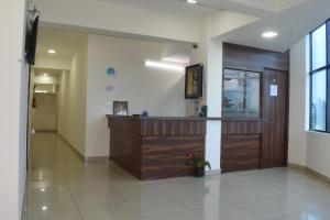 a lobby with a wooden door in a building at Sri Darshini Comfort 2kms from Hinkal Flyover in Mysore