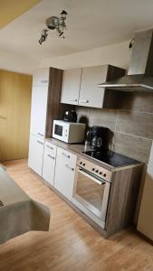 a kitchen with a stove and a microwave at FeWo Langewerth in Wilhelmshaven