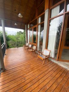 a deck with chairs and windows on a house at Mihidugiri Eco lodge in Kandy