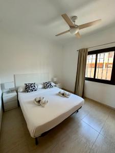 a bedroom with two beds and a ceiling fan at Triplex el Galeon in Adeje +8 photos