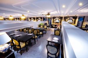 a restaurant with tables and chairs and a bar at Hanoi Indochine Premium Hotel in Hanoi