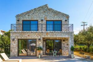 a stone house with a balcony on top of it at Neema Villa with Private Pool in Zakynthos