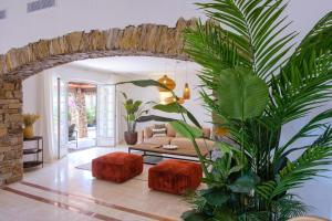 サント・マキシムにあるLovely luxury villa with garden and private poolのソファとヤシの木のあるリビングルーム