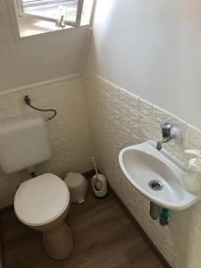 a bathroom with a white toilet and a sink at PäRLAN APARTMAN in Balatonboglár