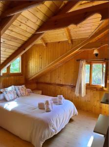 a bedroom with a bed in a wooden cabin at Casa de madera El Vado in Villanueva del Arzobispo