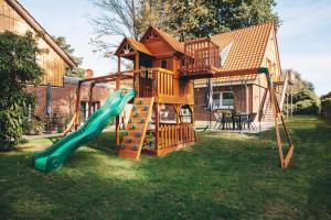 a playground with a tree house with a slide at Hünzinger Dorfschmiede in Walsrode