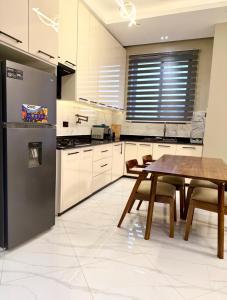 a kitchen with a wooden table and a dining room at Urban Sage Apartments in Kampala