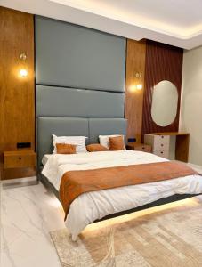 a bedroom with a large bed with a blue headboard at Urban Sage Apartments in Kampala