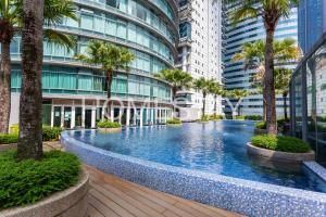 a swimming pool in a building with palm trees at Vortex Suites Klcc By Homestay in Kuala Lumpur
