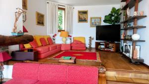 a living room with a pink couch and a flat screen tv at Villa St Michel in Brando