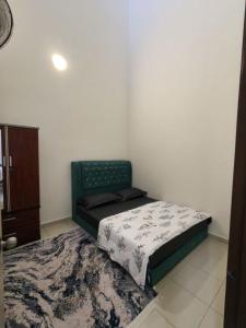 een kleine slaapkamer met een bed en een kleed bij Eiman Homestay in Kuala Terengganu
