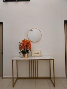 een tafel met een spiegel en een vaas met bloemen erop bij Eiman Homestay in Kuala Terengganu +2 foto's