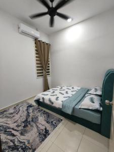 een slaapkamer met een bed en een plafondventilator bij Eiman Homestay in Kuala Terengganu