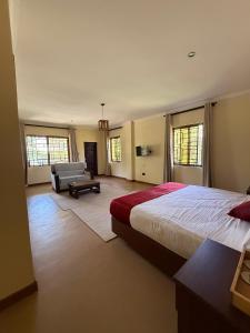 ein Schlafzimmer mit einem Bett und einer Couch in einem Zimmer in der Unterkunft Hillsgate Experience a Luxury Home in Nairobi in Nairobi + 205 Fotos