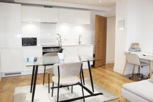 a kitchen and dining room with a glass table and chairs at Chelmsford Town Centre, Modern 1 Bed Apartment in Chelmsford