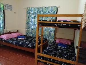 two bunk beds in a room with another bed at El Nido Cabugao Loudge in El Nido