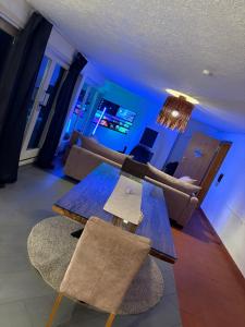 a living room with a wooden table and chairs at Sky Harmony Penthouse mit Wasserbett, Jacuzzi und Grill in Villingen-Schwenningen +4 photos