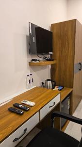 a room with a desk with a tv on it at Elite Hotel Karimnagar in Kottapalli