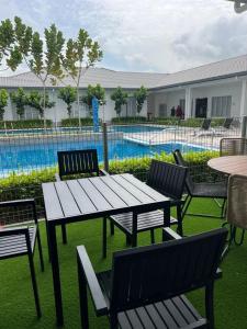 a picnic table and chairs next to a swimming pool at The Duta Loft in Bandar Puncak Alam