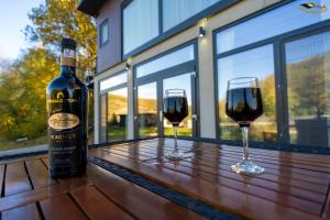 two glasses of red wine sitting on a wooden table at Casa Kaf in Sebeşel