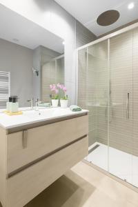 een badkamer met een wastafel en een douche bij Apartamentos La Gringa Centro Gijon I Obra nueva con posibilidad de Parking in Gijón +16 foto's