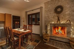 a dining room with a table and a fireplace at the mountain house in parnassus in Eptalofos