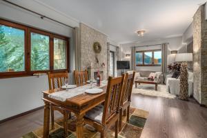 a dining room and living room with a table and chairs at the mountain house in parnassus in Eptalofos +25 photos
