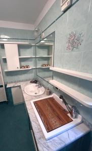 a bathroom with a sink with a wooden cutting board at Casa Checolongo in Ziano di Fiemme +6 photos