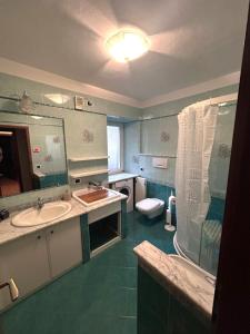 a bathroom with two sinks and a toilet and a mirror at Casa Checolongo in Ziano di Fiemme