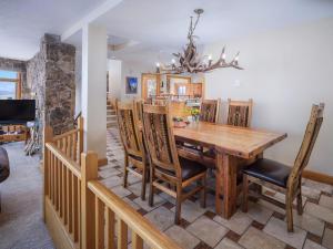 uma sala de jantar e cozinha com mesa e cadeiras de madeira em RMR: Tram Tower 12 Condo in Teton Village em Teton Village