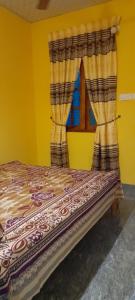 a bed in a yellow room with a window at Batti Relax Point Villa & Rooms in Batticaloa