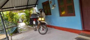 a motorcycle parked in front of a house at Batti Relax Point Villa & Rooms in Batticaloa