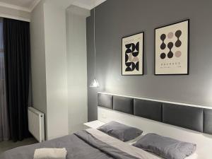 a bedroom with a bed and two pictures on the wall at Kutaisi Glow in Kutaisi