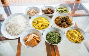 a group of bowls of food on a glass table at Mihidugiri Eco lodge in Kandy