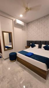 a bedroom with a large bed and a mirror at Elite Hotel Karimnagar in Kottapalli