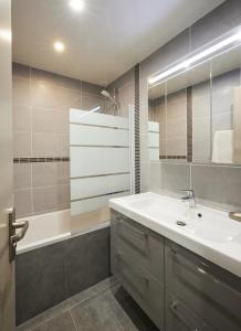 a bathroom with a white sink and a shower at Maison Harmonie entre Ocean et Nature in Saint-Jean-de-Monts