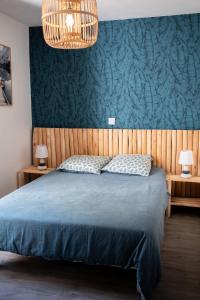 a bedroom with a blue bed with two pillows at Maison Harmonie entre Ocean et Nature in Saint-Jean-de-Monts