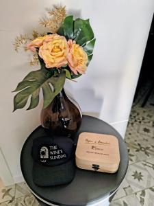 un jarrón con flores y un libro sobre una mesa en The Wine's Sundial, en Aiello del Friuli