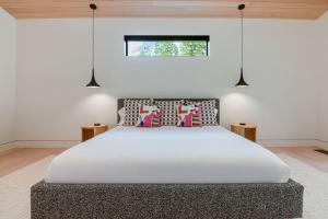 Un dormitorio con una cama con sábanas blancas y una ventana. en RMR: Tensleep Oasis Home in The AspensWilsonWY, en Wilson