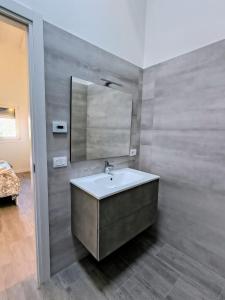 un baño con lavabo y espejo en The Wine's Sundial, en Aiello del Friuli