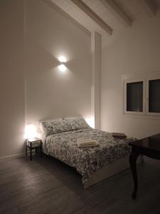 Un dormitorio con una cama y una mesa y una ventana. en The Wine's Sundial, en Aiello del Friuli