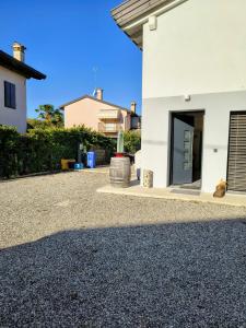 a white house with a gravel driveway at The Wine's Sundial AFFITTACAMERE in Aiello del Friuli