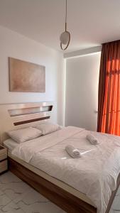 una camera da letto con un letto con due telefoni sopra di White Bridge Riverside a Kutaisi