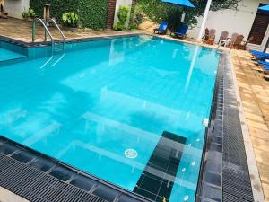 a swimming pool with blue water at Ceylan Lodge Anuradhapura in Anuradhapura +19 photos