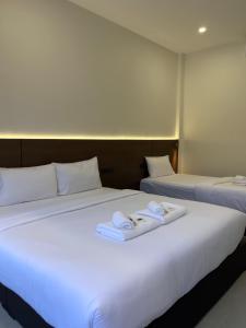 two beds in a hotel room with towels on them at วันทน่า พูลวิลล่า เนินมะปราง in Ban Mung