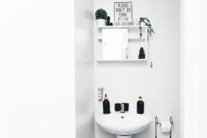 a white bathroom with a sink and a toilet at Charming GEM II 2BD 2BA Retreat in London