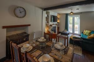 a living room with a table and a clock on the wall at Cottage style with lovely mountain views in Moffat