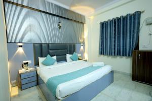 a bedroom with a large bed with a blue headboard at Hotel Basil Inn in Agra