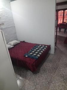 Un dormitorio con una cama con una manta roja. en El Encanto, en Mar del Plata